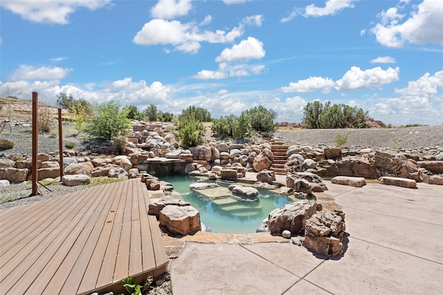 view of swimming pool with a hot tub