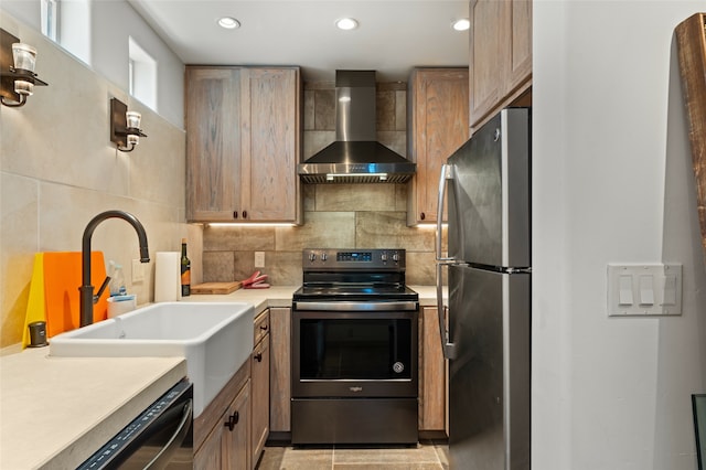 kitchen with decorative backsplash, electric range, wall chimney range hood, light tile patterned floors, and stainless steel fridge