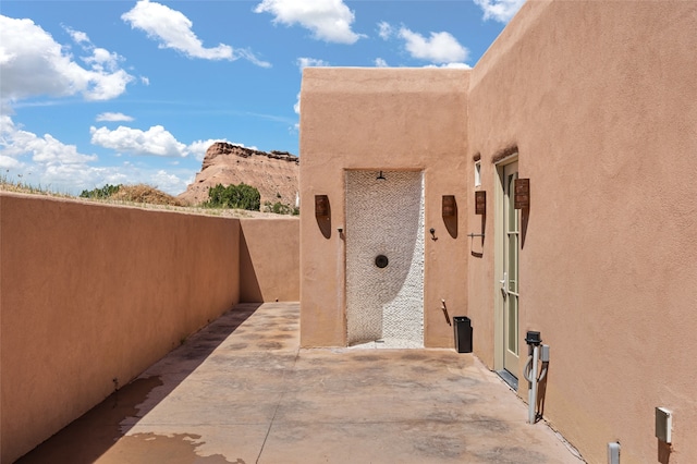 view of property exterior with a mountain view and a patio area