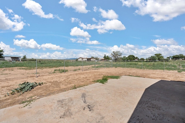 view of yard with a patio area, fence, and a rural view