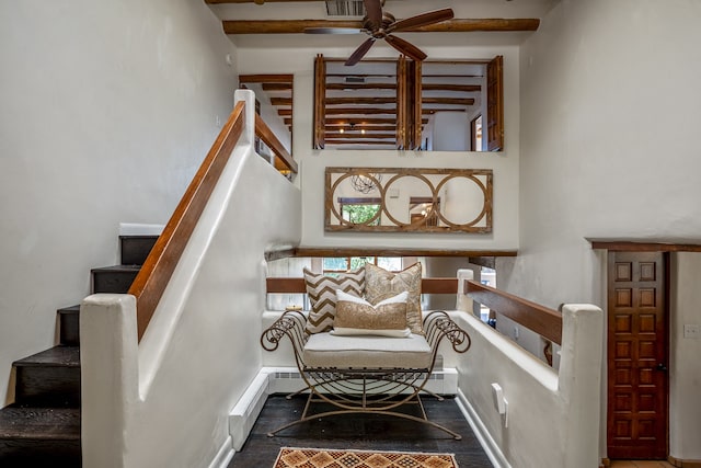 stairway with ceiling fan, beam ceiling, baseboard heating, and hardwood / wood-style floors