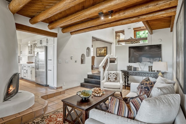 living room featuring light tile patterned floors, beam ceiling, and wooden ceiling