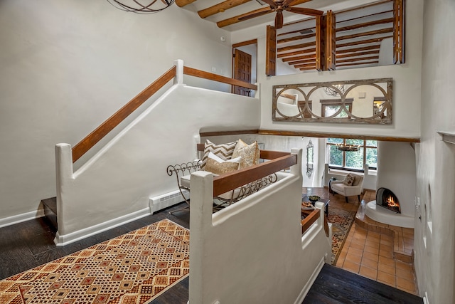 stairway with beam ceiling and hardwood / wood-style floors