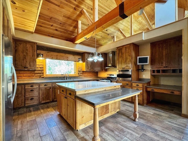 125 Tierra Del Dios, Rowe, NM 87562 - kitchen with brown cabinets, a sink, a kitchen island, appliances with stainless steel finishes, and wall chimney range hood