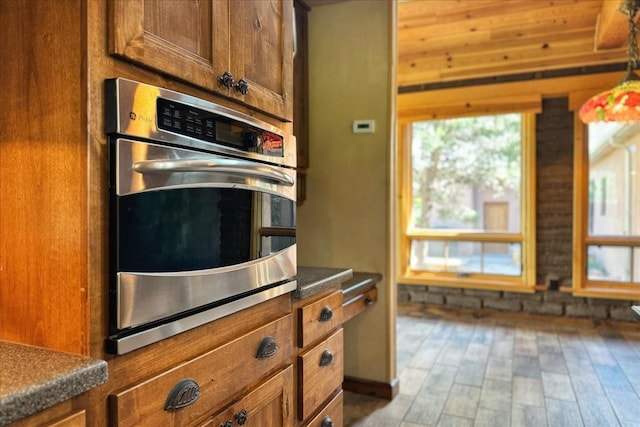 125 Tierra Del Dios, Rowe, NM 87562 - kitchen with dark countertops, wood finished floors, and brown cabinetry