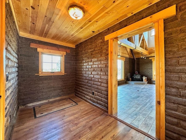 125 Tierra Del Dios, Rowe, NM 87562 - unfurnished room with plenty of natural light, wood ceiling, wood finished floors, and a wood stove