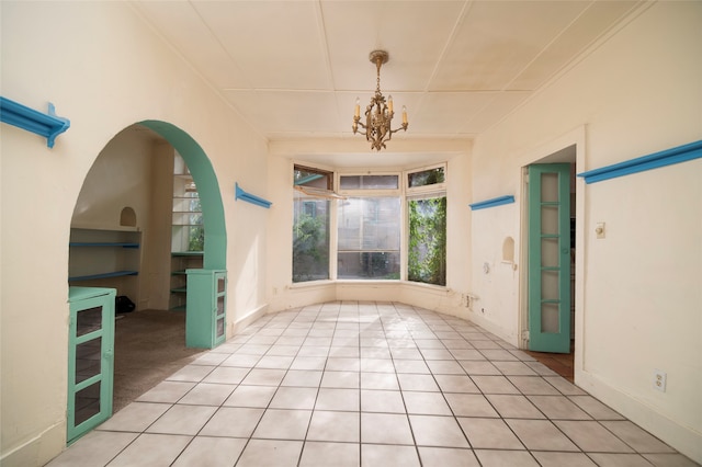 interior space with crown molding, an inviting chandelier, and light tile patterned floors