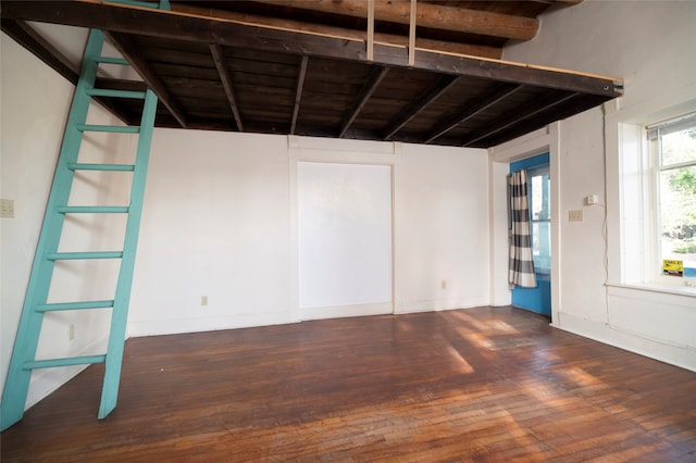 empty room with dark hardwood / wood-style floors, beam ceiling, and wooden ceiling