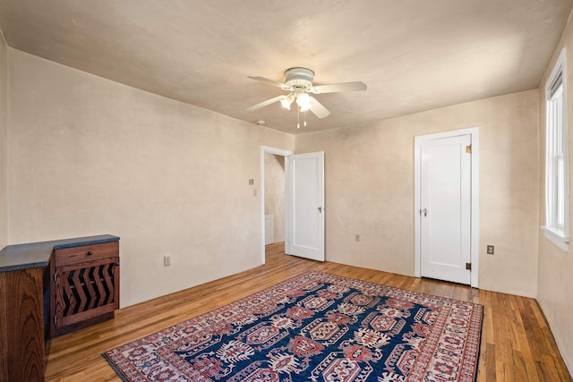 bedroom featuring multiple windows, light hardwood / wood-style floors, and ceiling fan