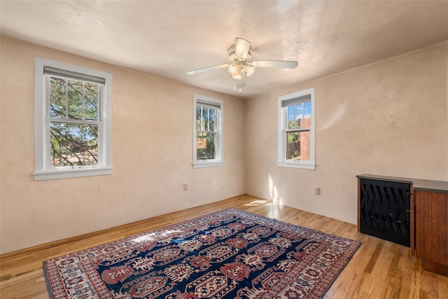 unfurnished room featuring light hardwood / wood-style flooring, ceiling fan, and a healthy amount of sunlight