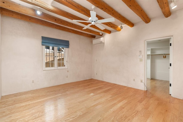 unfurnished room with an AC wall unit, ceiling fan, beamed ceiling, and light hardwood / wood-style floors