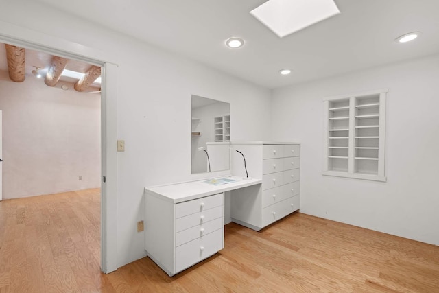 spacious closet with beam ceiling and light wood-type flooring