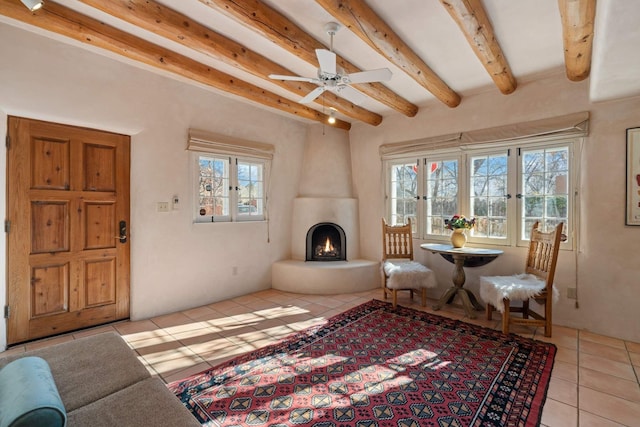 living area featuring a fireplace, light tile patterned floors, plenty of natural light, and ceiling fan