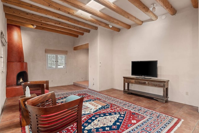 living room with tile patterned flooring, beam ceiling, and a large fireplace