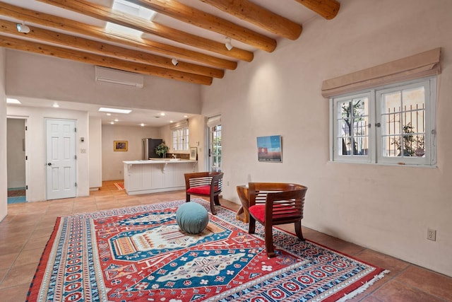 sitting room featuring beam ceiling, light tile patterned floors, and a wall unit AC