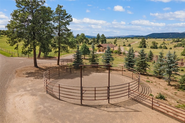 view of property's community with an exterior structure, an enclosed area, a rural view, and a mountain view