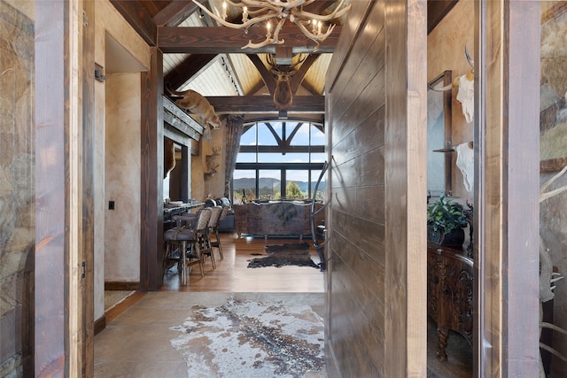 entryway with lofted ceiling with beams, wood ceiling, and an inviting chandelier