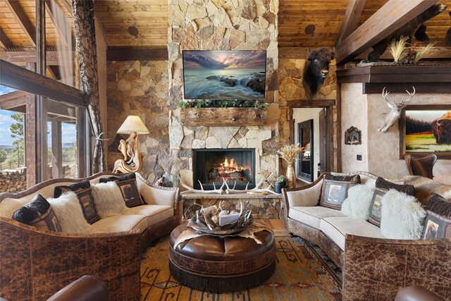 living room with beamed ceiling, wooden ceiling, hardwood / wood-style floors, and a stone fireplace