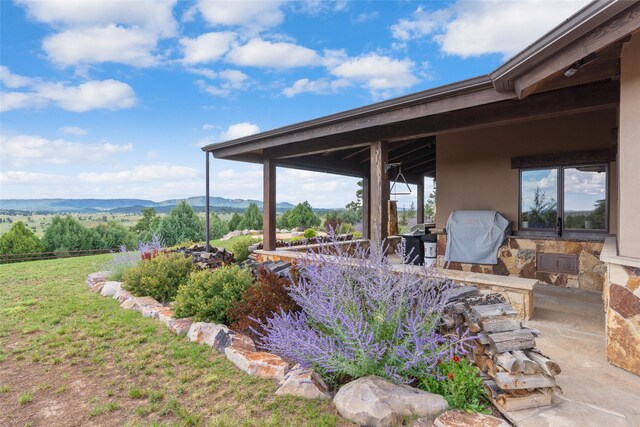 view of yard featuring a mountain view and a patio area