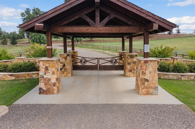 view of home's community with a rural view, fence, and a gazebo