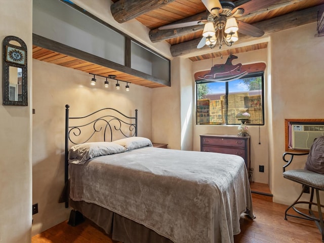 bedroom featuring track lighting, an AC wall unit, beam ceiling, wooden ceiling, and wood finished floors