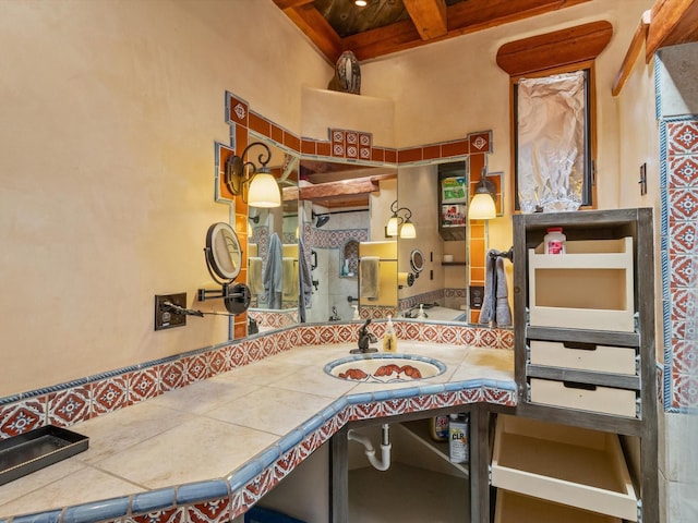 interior space with beam ceiling, coffered ceiling, and vanity