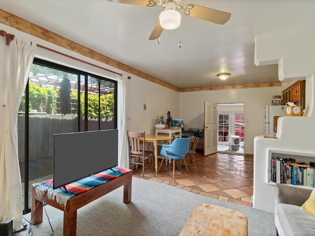 living area with light tile patterned floors and a ceiling fan