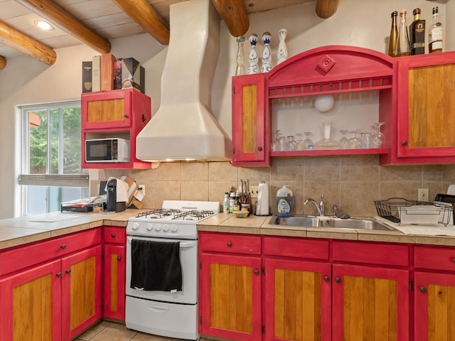 kitchen featuring white range with gas cooktop, backsplash, island exhaust hood, and a sink