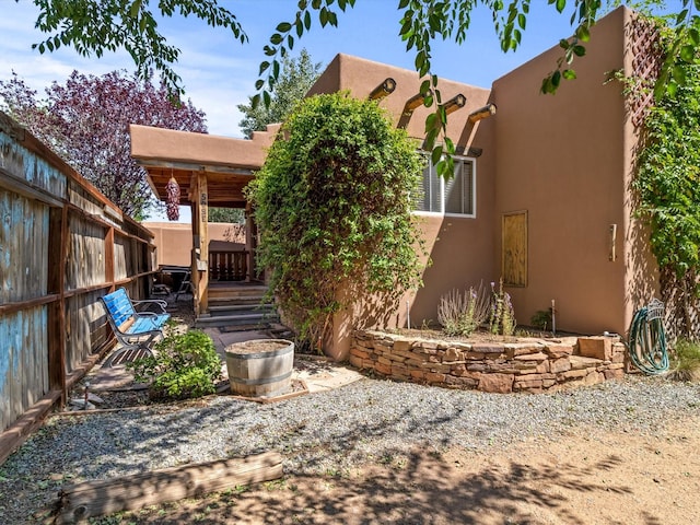 exterior space with stucco siding, a patio, and fence