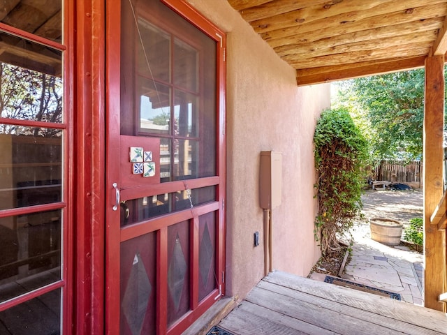 entrance to property with stucco siding and fence