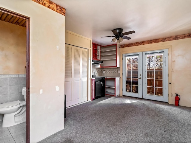 unfurnished living room with dark colored carpet, dark tile patterned flooring, ceiling fan, and a sink