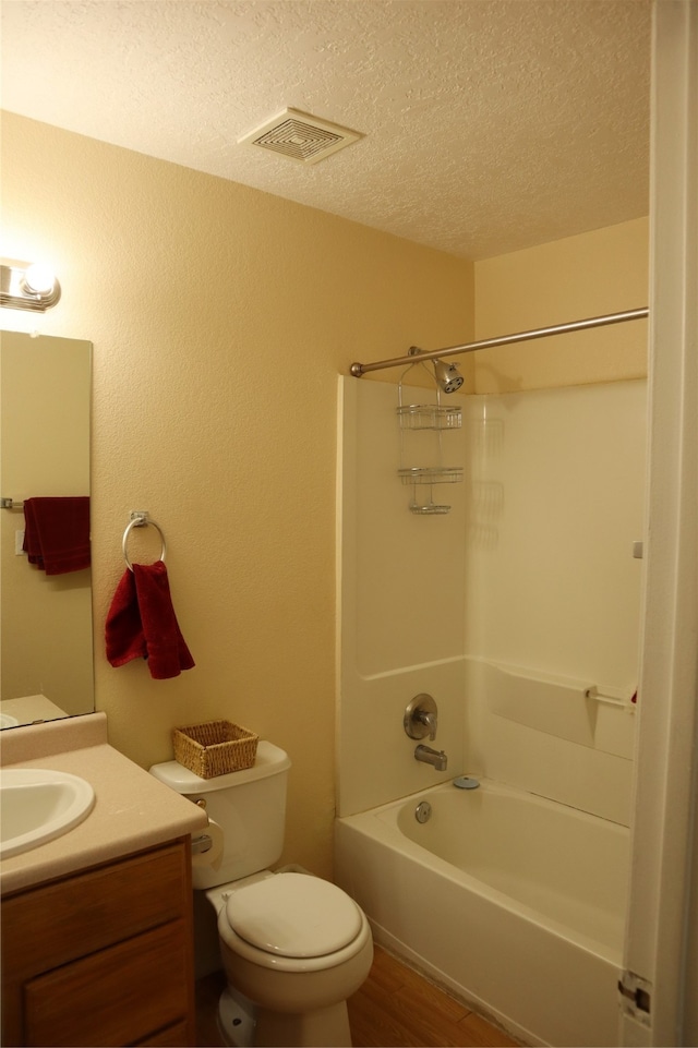 full bathroom with toilet, vanity, hardwood / wood-style floors,  shower combination, and a textured ceiling