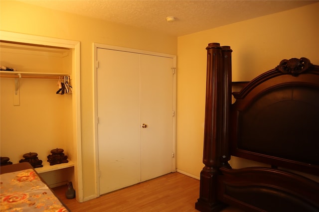 bedroom with light hardwood / wood-style floors and a textured ceiling