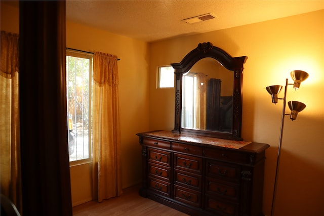 bedroom with light hardwood / wood-style flooring and a textured ceiling