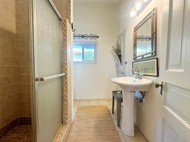 bathroom with tile patterned floors, sink, and a shower with shower door