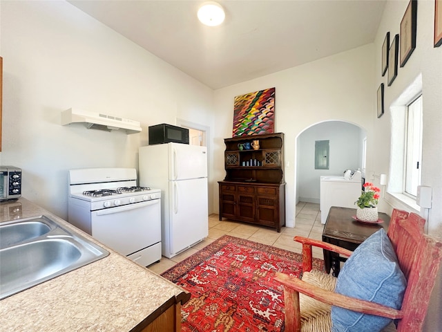 kitchen featuring light tile patterned flooring, sink, custom exhaust hood, white appliances, and washer and clothes dryer