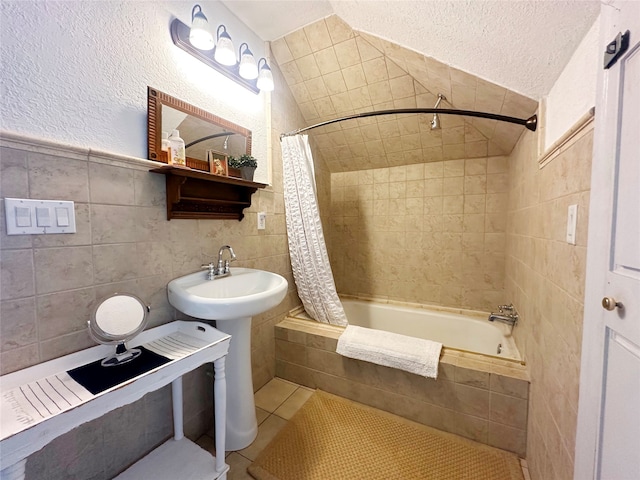 bathroom featuring tile walls, tile patterned flooring, a textured ceiling, and shower / bathtub combination with curtain