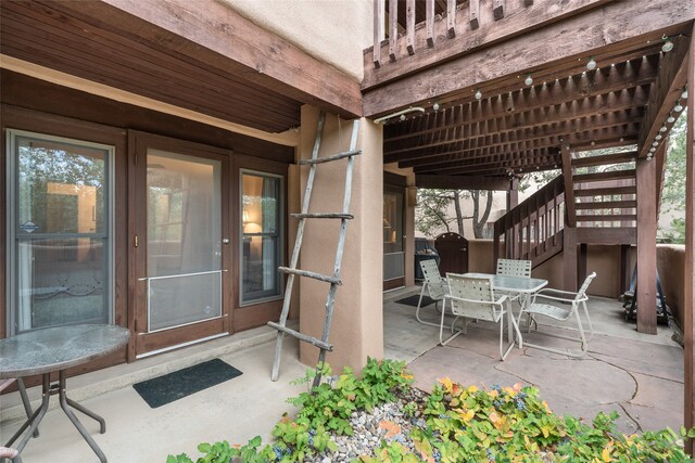 view of patio featuring outdoor dining area and stairway