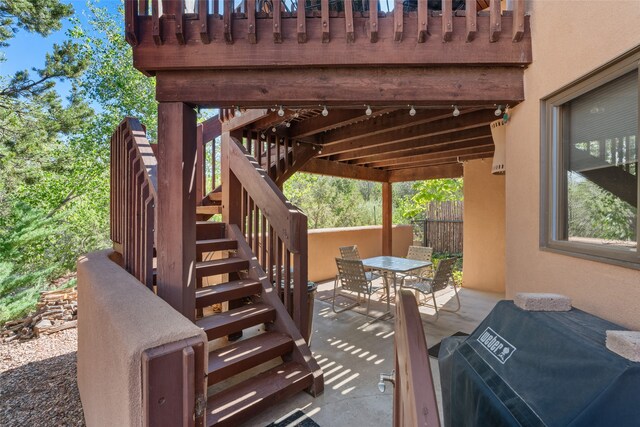 view of patio featuring stairs, outdoor dining space, area for grilling, and fence