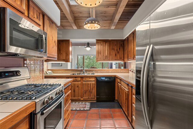 kitchen featuring a sink, stainless steel appliances, brown cabinetry, and light countertops