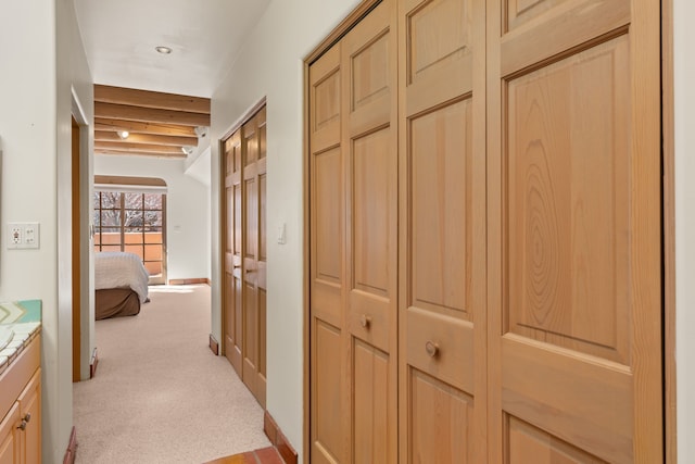 hallway with light colored carpet and baseboards