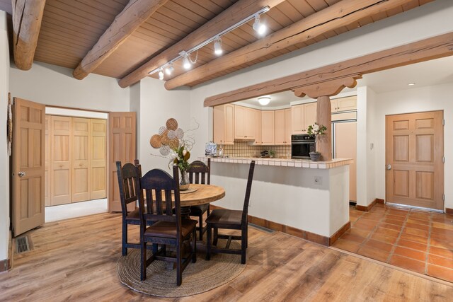 unfurnished living room with beam ceiling, light wood-type flooring, wooden ceiling, ceiling fan, and a fireplace