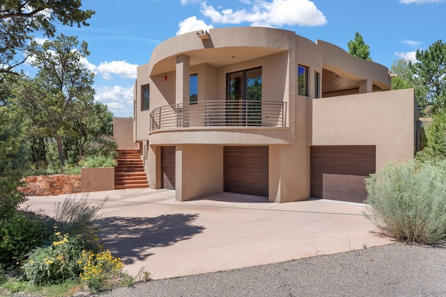 pueblo revival-style home with a balcony and a garage