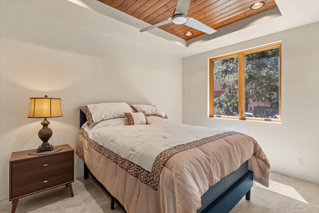 bedroom with a tray ceiling, ceiling fan, and wooden ceiling