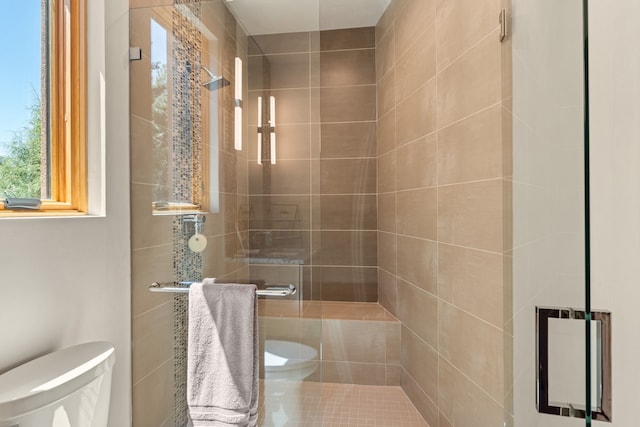 bathroom with tiled shower and toilet