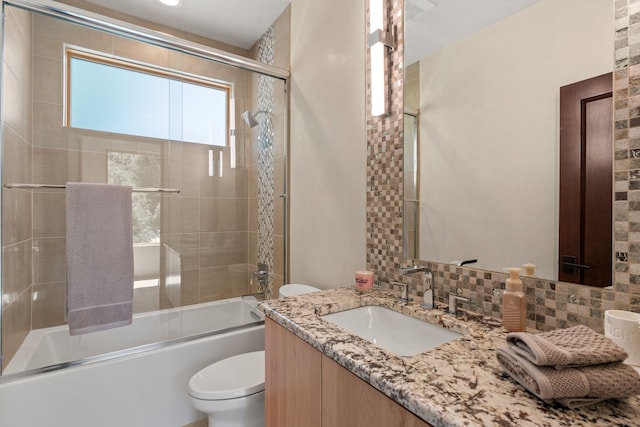 full bathroom with tasteful backsplash, toilet, combined bath / shower with glass door, and vanity