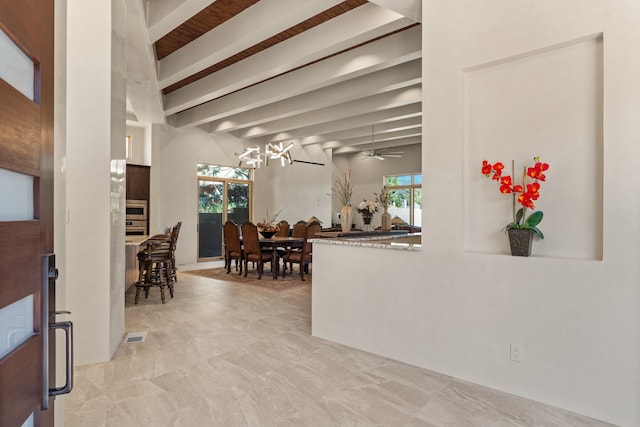 interior space featuring an inviting chandelier, beam ceiling, and a healthy amount of sunlight