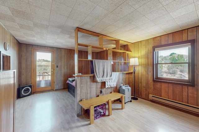 sitting room featuring wood walls, a baseboard radiator, and hardwood / wood-style floors