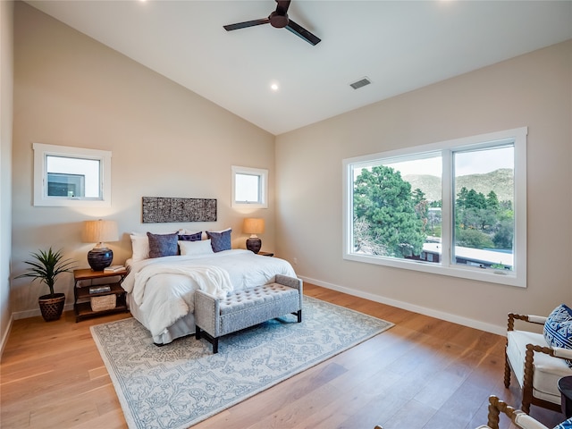 bedroom with ceiling fan, light hardwood / wood-style floors, and lofted ceiling