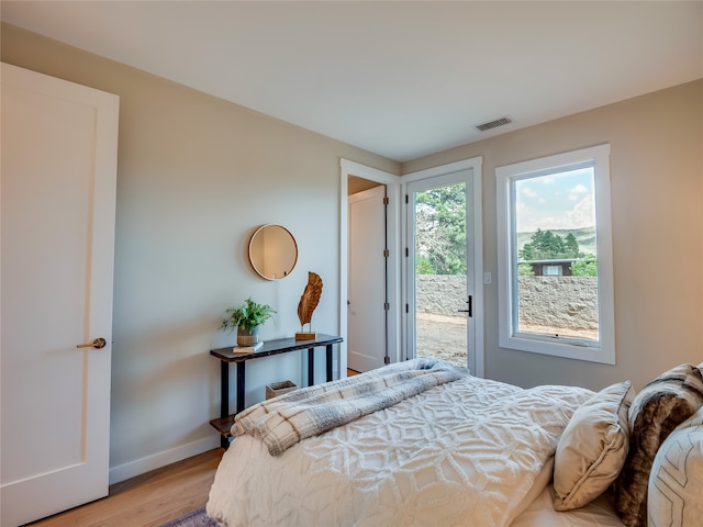 bedroom featuring access to exterior and light wood-type flooring